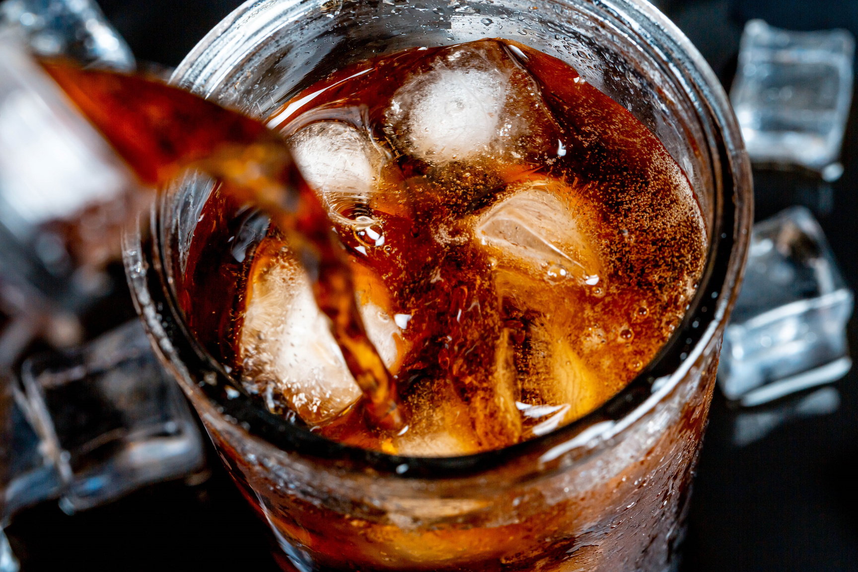A Glass of Cold Pepsi with Ice on a Dark Background
